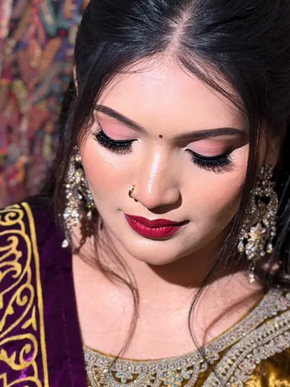 A minimal but glowy makeup look. This close-up shows the soft pink eyeshadow, winged liner, and bold red lip, perfect for any festive occasion.