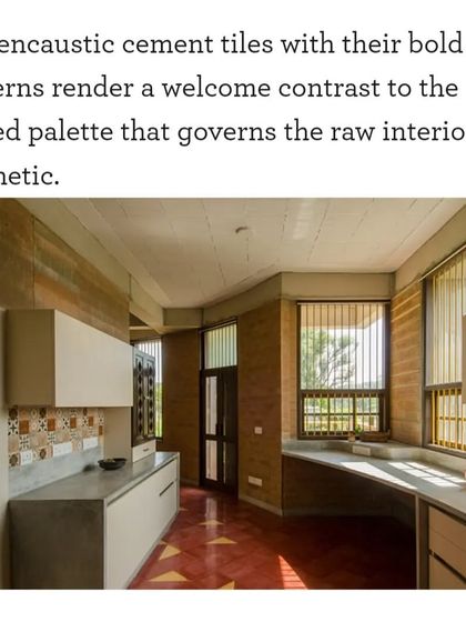 The kitchen in "Breathe" features encaustic cement tiles that provide a bold pattern against the raw, muted palette of the rammed earth walls and concrete countertops. This contrast adds a welcome decorative element to the functional space.