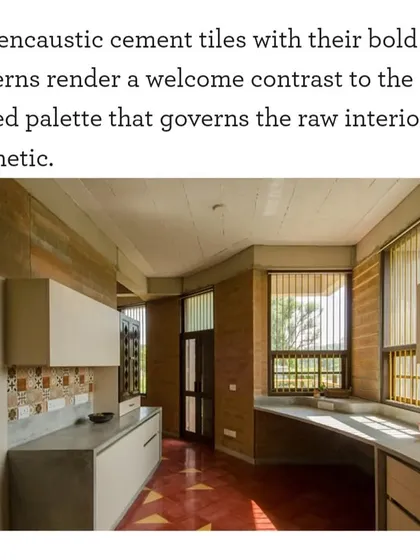 The kitchen in "Breathe" features encaustic cement tiles that provide a bold pattern against the raw, muted palette of the rammed earth walls and concrete countertops. This contrast adds a welcome decorative element to the functional space.