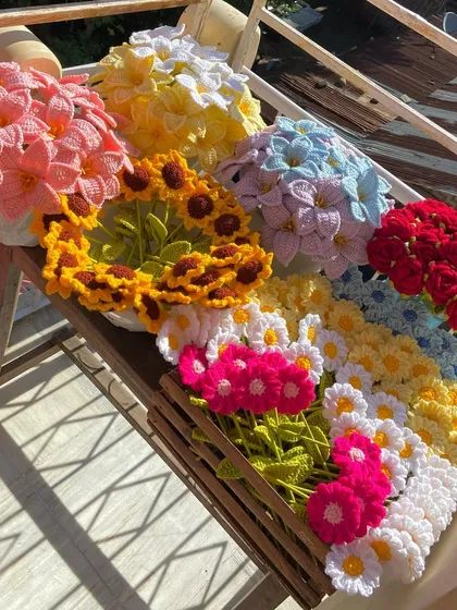 A beautiful outdoor shot of a huge order, including bouquets of lilies, roses, and sunflowers.