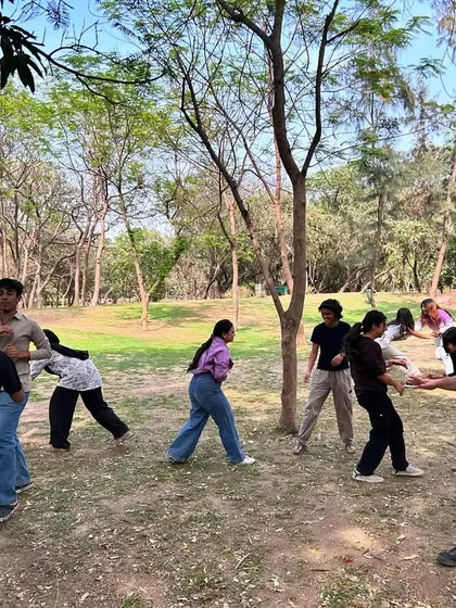 We often take our training outdoors to prepare for different environments. Here, a group of students practices defense against multiple attackers in a park, learning to use space and awareness outside the gym.