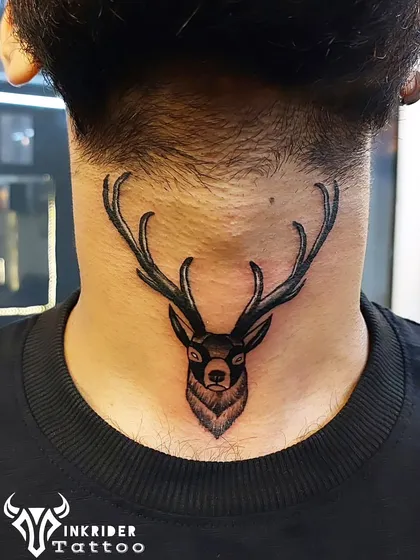 A strong and noble deer tattoo on the back of the neck. The bold lines and shading give this piece a powerful presence, symbolizing peace and good luck.
