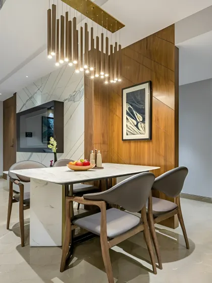 Our dining spaces are crafted to bring people together in style. This area is defined by a striking wooden partition, a modern marble-top table, and a dramatic chandelier, creating an elegant setting for memorable meals.