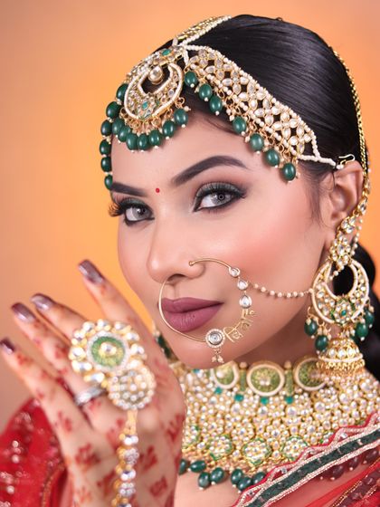 This stunning look with green eyeshadow and a bold lip was created in our bridal makeup class. We teach students how to play with color to complement bridal outfits.