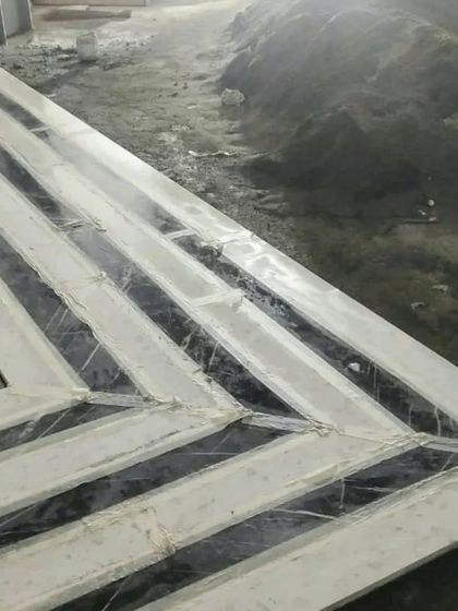 A marble staircase that appears to be carved from a single block of stone. The continuous veining across the steps and wall creates a powerful visual statement, showcasing our attention to detail in material selection and installation.