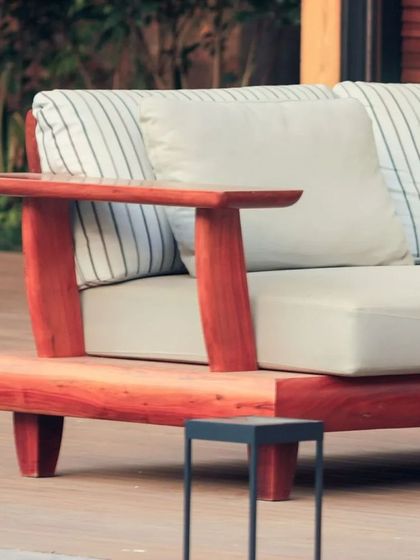 Detail of the outdoor sofa, showcasing its sturdy wooden frame and comfortable, weather-resistant cushions. Every piece is chosen for both its aesthetic appeal and its ability to withstand the elements.