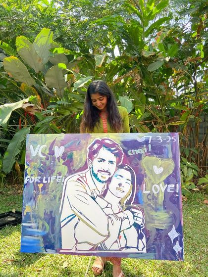 Holding up the finished couple's portrait. The abstract, colorful background was filled in by guests, making it a truly collaborative piece.