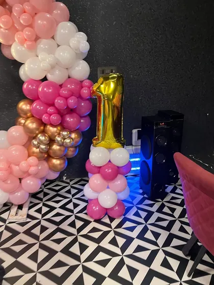 A number '1' foil balloon on a matching balloon stand, highlighting the milestone first birthday.