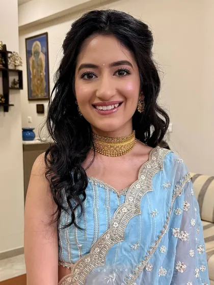 The perfect Roka glow. This look is all about fresh, luminous skin and subtle definition to enhance her natural beauty, pairing beautifully with her pastel blue outfit for a touch of timeless elegance.
