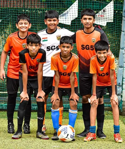 A boys' youth team posing with their football, embodying the spirit of grassroots competition.
