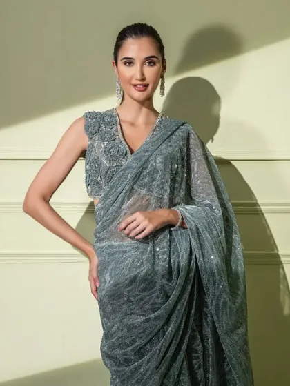 A happy model wearing the grey sequined saree, showing how it combines sparkle with sophisticated floral craftsmanship.