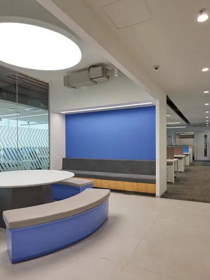 A collaboration zone with curved blue benches and a round table. This setup is ideal for informal group discussions and teamwork.