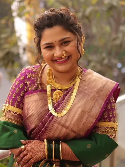 A bright, happy portrait of the bride on her wedding day. The combination of the purple embroidered blouse, gold jewelry, and her joyful smile creates a timeless bridal look.