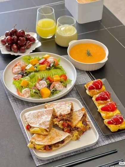 A complete and balanced meal spread, including quesadillas, shrimp salad, soup, and a fruit dessert. This shows our ability to create a full-course menu.