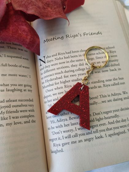 For those who love a bit of drama, this 'A' keychain is made with a bold poppy red shimmer. It’s a simple accessory that makes a statement.