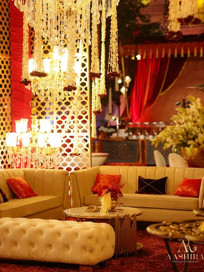 Plush lounge seating under a canopy of hanging tuberose chandeliers, with rich red and black cushions adding to the opulent and comfortable atmosphere.