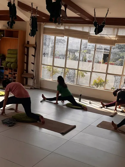 A class works on deep hip-opening lunges, a great stretch for releasing tension.