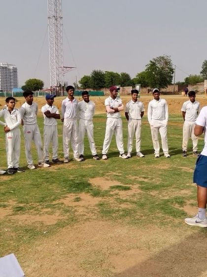 An outdoor session where our coach discusses game strategy with a group of young players. These on-field discussions are crucial for developing game awareness and tactical thinking.