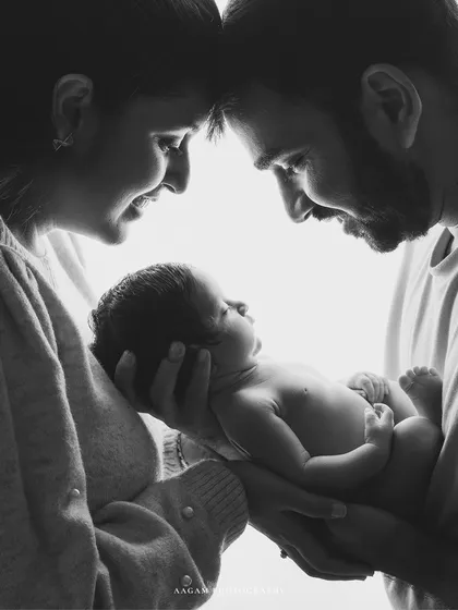 A family born in one magical moment. This backlit portrait captures the awe and wonder in the parents' eyes as they gaze at their newborn.