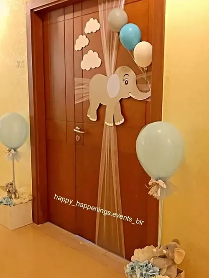 The celebration starts at the door. For our elephant-themed baby welcome, we created this charming door decoration featuring a baby elephant cutout, fluffy clouds, and balloons to greet guests.
