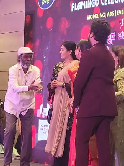 A candid moment on stage during the "ದಶಕದ ಸಂಭ್ರಮ" (Decade's Celebration) event, featuring esteemed guests and artists. I ensure the stage is well-lit and organized for such important interactions.