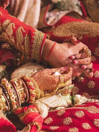 A close-up of the couple's hands during a wedding ritual, a symbol of their eternal bond.