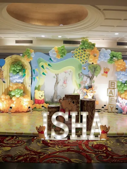 I brought the Hundred Acre Wood to life for this Winnie the Pooh themed event. The full stage setup includes character cutouts, a balloon arch mimicking trees and clouds, and illuminated letters spelling the baby's name, creating an immersive storybook experience.