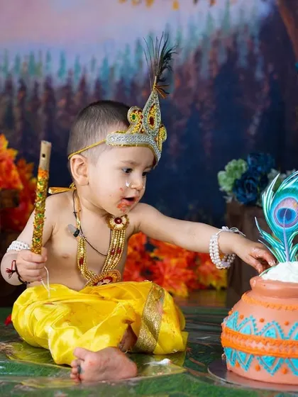 A first birthday celebration with a Krishna theme cake smash. This little one is curiously inspecting his butter pot cake.