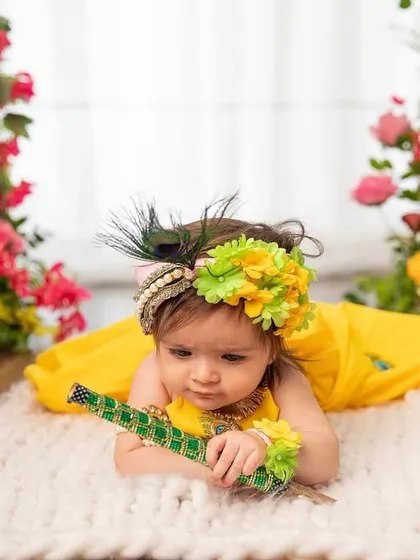 Our little Radha, dressed in yellow and holding a flute. The soft textures and colorful flowers create a beautiful and gentle portrait.
