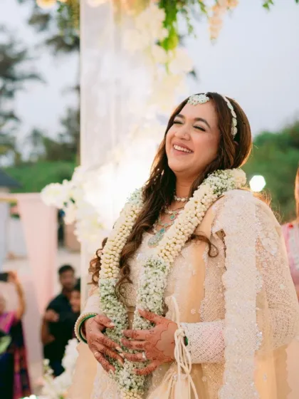 This bride is glowing with joy. Her soft-glam makeup, featuring a dewy base and nude pink lips, is the perfect example of a trendy yet timeless bridal look.