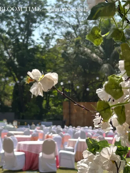 The setting is just as important as the food. Here, we prepared for a beautiful outdoor wedding reception, with tables set amidst blooming flowers and lush greenery for a perfect summer celebration.