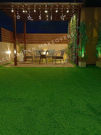 An evening view of a terrace I designed. The artificial grass and green walls stay perfectly green, creating a beautiful entertaining space under the star-shaped string lights of the pergola.