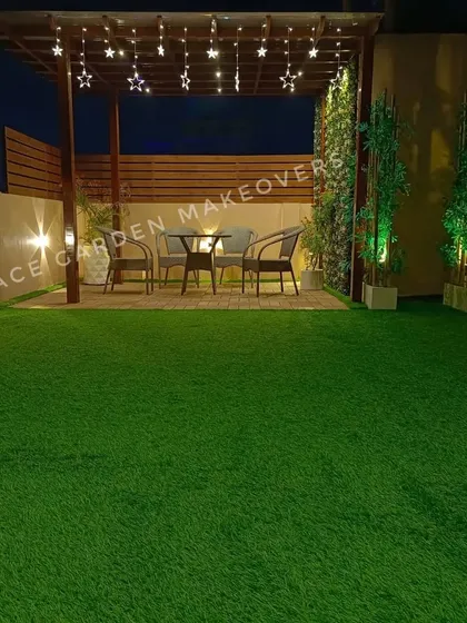 A wider view of our pergola dining area project. The combination of the wooden structure, privacy screening, artificial grass, and ambient lighting creates a complete and inviting outdoor room.