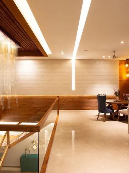 In this residential foyer, light becomes the jewellery of the architecture. A cascading crystal chandelier appears to pour down the stairwell, creating a breathtaking first impression. This is complemented by integrated linear lighting and subtle wall washing to create layers of warmth and sophistication.