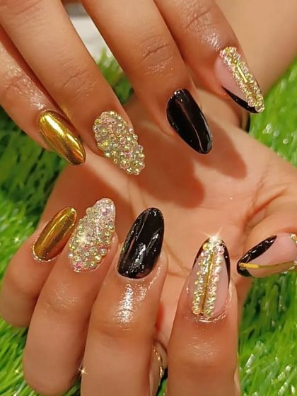 The ultimate statement nails, this set combines black and gold chrome, full-coverage crystals, and gold rhinestone chains for maximum impact.
