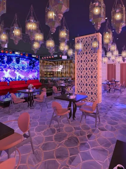 A wider view of the lounge, showing the stage and performance area. The design combines traditional patterns on decorative screens with modern elements like a large LED screen, creating a versatile space for entertainment.