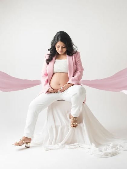 A touch of magic and elegance. This shot combines a modern pantsuit with flowing pink fabric, creating a dreamy and artistic portrait that is both stylish and soft.