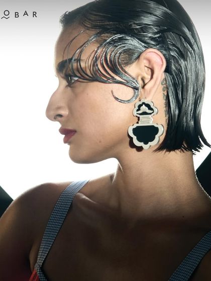 A close-up on a model wearing statement earrings from Nicobar, showcasing their unique and modern accessory designs available during the sale.