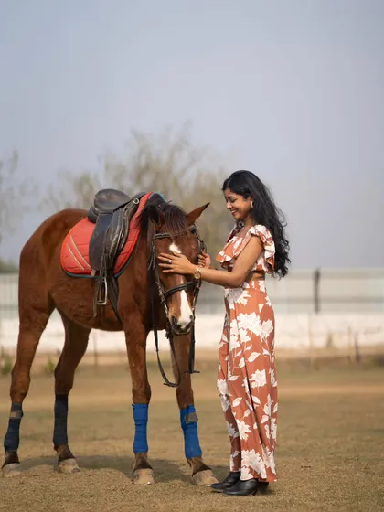 A tender moment as the model gently pets the horse, captured in the wide-open field.