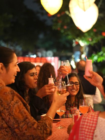 Guests toasting at an evening event we catered. We often manage the bar service as well, crafting special cocktails to complement the food and the occasion.