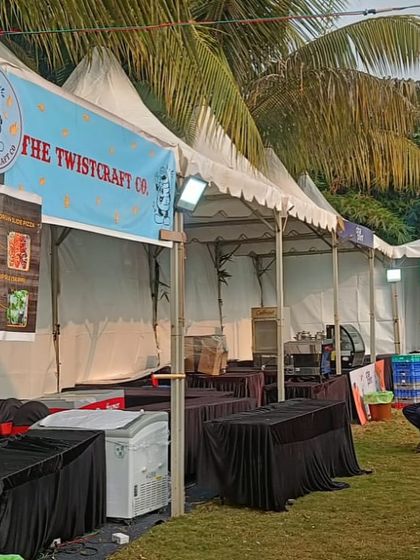 A row of food and product stalls at Pet Fed Pune. I ensure each vendor has the necessary space, tables, and lighting to operate effectively throughout the event, day and night.