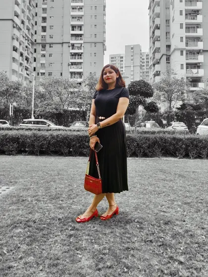 A similar shot of the all-black outfit with red accessories, showing a full-length view of the classic, elegant style.