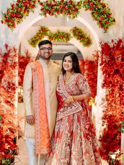 A happy portrait of the couple at their reception, with the decor designed to create beautiful, memorable frames for their wedding album.