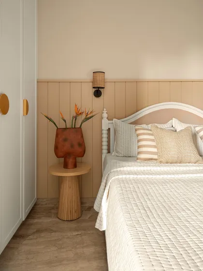 This guest bedroom is a warm, neutral retreat. The bed features a simple, classic headboard, and the wall behind it has wainscoting in a soft beige tone, creating a calm and simple space.
