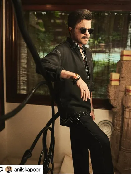 A full-look shot of Anil Kapoor. The hairstyle holds its shape perfectly, completing his sharp and stylish ensemble.