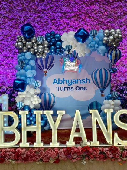 A close-up of the main stage for the Hot Air Balloon theme, showing the custom backdrop, balloon clouds, and marquee letters.