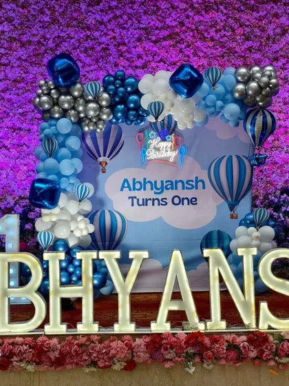 A close-up of the main stage for the Hot Air Balloon theme, showing the custom backdrop, balloon clouds, and marquee letters.