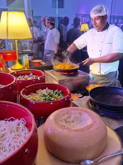 We bring the action to your guests with engaging live food stations. Here, our chef prepares fresh pasta, tossing it in a giant wheel of Parmesan cheese for an interactive and delicious experience at a Mercedes-Benz launch event.