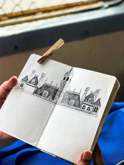 A page from my sketchbook featuring a detailed drawing of a historic Mumbai building, captured while traveling on a local train.