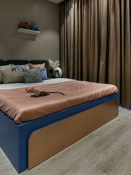 I designed this guest room with a mix of cool and warm tones to be both inviting and stylish. The classic blue wardrobe, shimmering champagne wallpaper, and warm wooden floor create a modern twist on classic design.